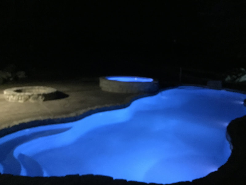fiberglass pools at night with lights and spa